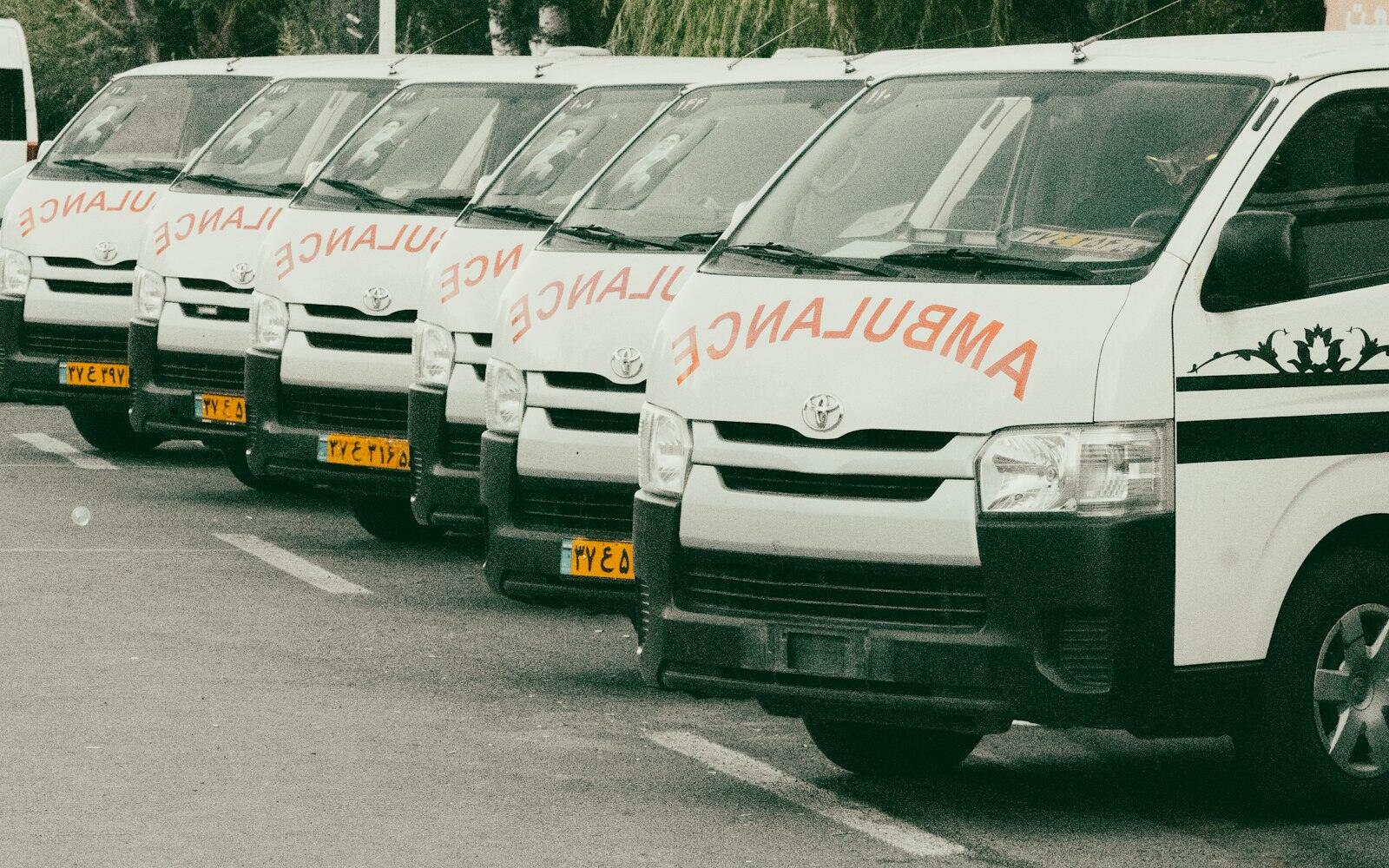 Ambulanze bianche parcheggiate in fila nel piazzale di una sede operativa